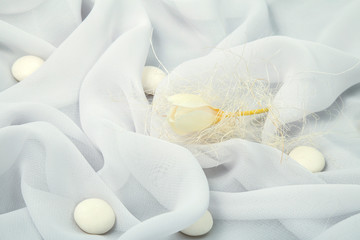 Wall Mural - white background of soft fabric lined with folds with spring white freesia and round candies