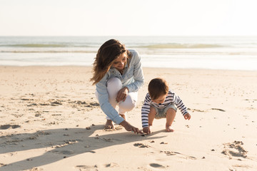 Wall Mural - Mother at the beach with toddler