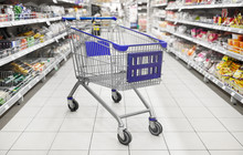 Consumerism Concept - Empty Shopping Cart Or Trolley At Supermarket