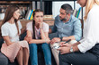 © LIGHTFIELD STUDIOS - cropped image of female counselor writing in clipboard while parents cheering up daughter on therapy session
