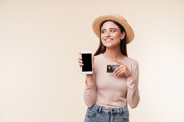 Amazing young pretty woman showing display of mobile phone holding credit card.