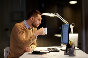 it, deadline and people concept - man with cup of coffee working on computer code at night office