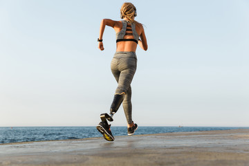 Wall Mural - Young amazing disabled sports woman running