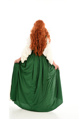 Poster - full length portrait of red haired girl wearing long green gown,. standing pose with back to the camera, isolated on white studio background.