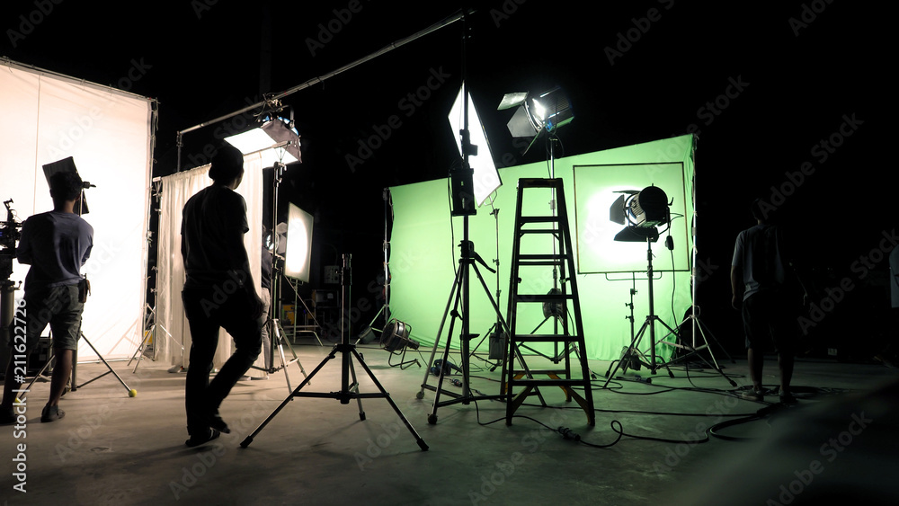 Behind the scenes of TV commercial movie film or video shooting production which crew team and camera man setting up green screen for chroma key technique in big studio. - obrazy, fototapety, plakaty 