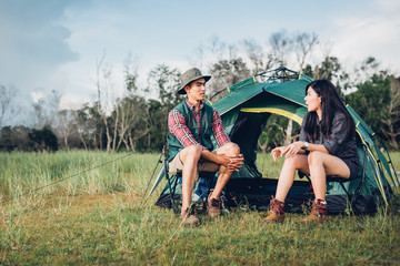 young couple sitting discuss camping tent together