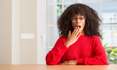 Poster - African american woman wearing glasses cover mouth with hand shocked with shame for mistake, expression of fear, scared in silence, secret concept