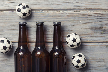 beer bottle with soccer football balls on a wooden background