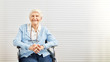 Alte Frau sitzt lächelnd im Rollstuhl im Seniorenheim