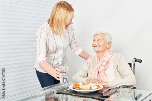 Fotografía Pflegedienst Frau serviert alter Frau ein Essen