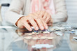 Hände von Senioren beim Puzzle spielen