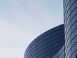 © nuchao - 3D stimulate of high rise curve glass building and dark steel window system on blue clear sky background,Business concept of future architecture,lookup to the angle of the corner building.3d rendering