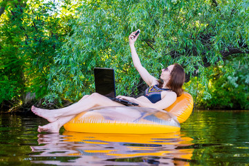 Wall Mural - Business woman sitting in an inflatable ring in a river space.