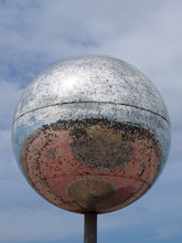 A Giant Glitter Ball On Blackpool Promenade With Blue Sky And Reflection Of The Town In The Mirrored Surface On A Sunny Day With Blue Sky
