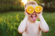 © stopabox - child with halves of oranges on eyes. happy child having fun and showing tongue
