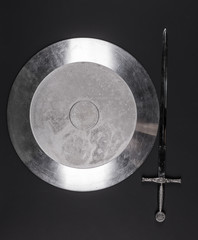 Poster - shiny metal shield and sword on a black isolated background