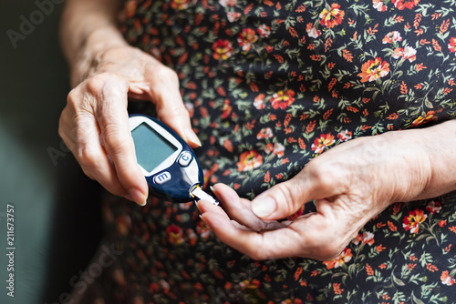 Fotografía Old lady tracking her glucose levels. Health concept