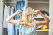 girl near a wardrobe with clothes can not choose what to wear. Heavy Choice Concept has nothing to wear