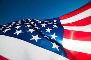 Close up United States of America flag on the blue sky background. USA Independence day, 4 July.