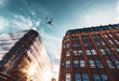 © Train arrival - Jet plane aircraft traveling in the sky over the center of Glasgow city buildings.