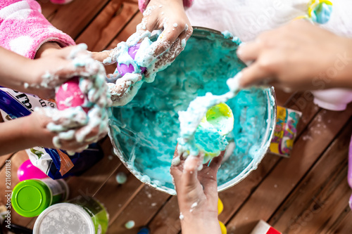 Fotomural A group of young girls, children make a mess with frothy slime at a birthday par