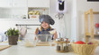 © KONSTANTIN SHISHKIN - Little girl baker puts batter to the pastry dough for cooking biscuits