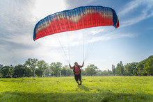 Young Man Exercising With A Parachute, Para Glider Doing Exercises In A Park