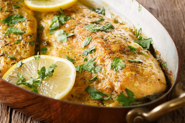 Canvas Print - Delicious food: trout fish with garlic lemon butter sauce, parsley close-up in a copper frying pan. horizontal