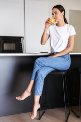 Sticker - Attractive young asian woman drinking orange juice