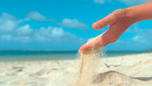 CLOSE UP: Tiny Grains Of Sand Get Swept Away From Female Hand By Summer Breeze