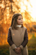 © Aleksandr - Little girl in autumn coat posing for photographer. Golden autumn