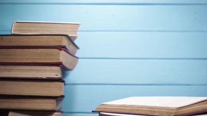 Poster - Open old book on a white wooden table, rotation 360 degrees.  Beautiful blue wooden background.