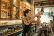 © mavoimages - Young female bartender mixing cocktails behind a bar counter