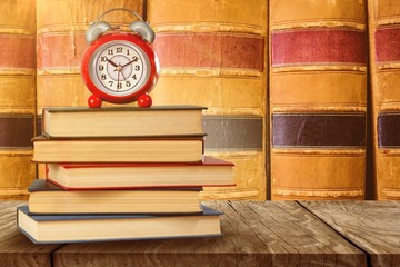 Wall Mural - Composite image of old alarm clock and stack of books