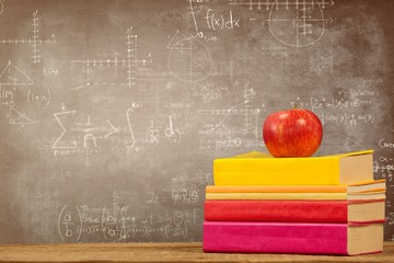 Poster - Composite image of apple with books on wooden table