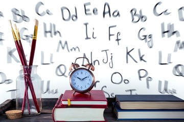 Canvas Print - Books with alarm clock with books and paintbrushes on wooden