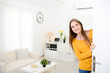 © W PRODUCTION - cheerful young woman welcome friends at open front door new student home apartment