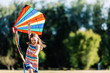 © Photocreo Bednarek - Smiling little girl playing with a colorful kite in the park.