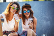 © BalanceFormCreative - Two female friends hangout at the city street.Laughing and fun.Drinking juice.