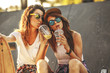 © BalanceFormCreative - Two female friends hangout at the city street.Laughing and fun.Drinking juice.