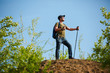 © snedorez - Picture of man with backpack and walking sticks on hill