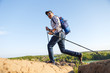 © snedorez - Image of young tourist man with walking sticks walking in mountainous area