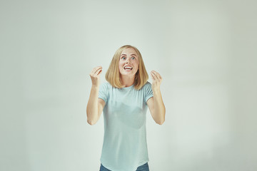 Wall Mural - Beautiful female half-length portrait isolated on gray studio backgroud. The young emotional surprised woman