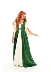 Canvas Print - full length portrait of red haired girl wearing long green medieval gown. standing pose, isolated on white studio background.