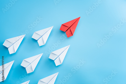 Fotomural Leadership concept with red paper plane leading among white on blue background