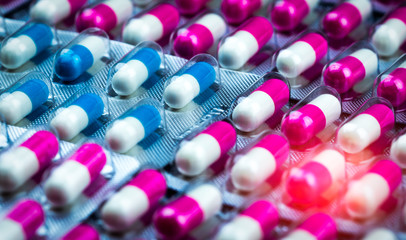 Poster - Closeup pink-white and blue-white antibiotics capsule pills in blister pack. Antimicrobial drug resistance. Pharmaceutical industry. Global healthcare. Pharmacy background. Amoxicillin capsule pills.