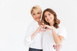 © Drobot Dean - Portrait of lovely family mother 40s and daughter 16-18 making heart symbol together with fingers, standing isolated over white background