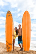 Beach surf fun. Happy surfers young tourists people posing with long orange surfboards in Hawaii beach after class. Male surfing instructor with Asian tourist on Maui beach having fun.