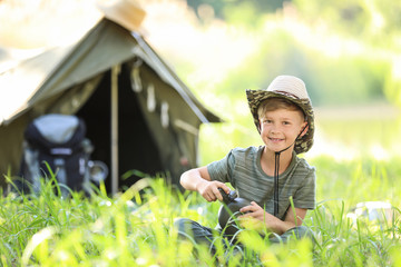 Sticker - Little boy with flask near tent outdoors. Summer camp