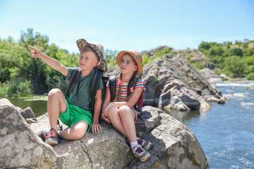 Wall Mural - little children on rock near river. summer camp
